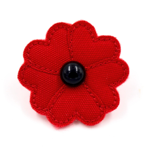 A red fabric poppy flower accessory with a glossy black button center, shown on a plain white background.