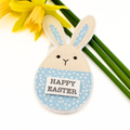 Fabric Easter bunny decoration and 'Happy Easter' message, surrounded by daffodils.