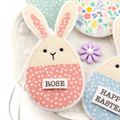 Fabric bunny decoration with 'Rose' label on a white plate with floral decorations