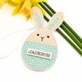 Fabric bunny Easter decoration with 'JACKSON' label, yellow flowers in the background
