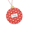 A personalised round Christmas ornament featuring a red and white geometric star pattern with gold star accents, a white name label reading 'AILSA', and a red-and-white striped hanging string with a gold glitter cap.